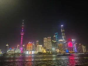 Night view of Shanghai’s Lujiazui skyline with the Oriental Pearl Tower and city lights reflecting on the river.